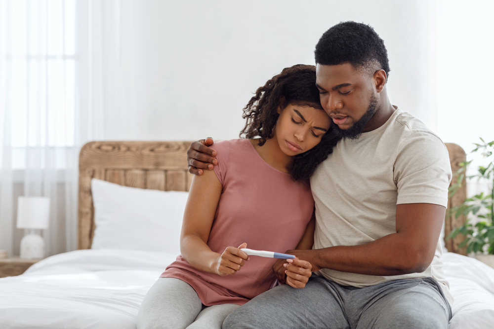 Couple looking at negative pregnancy test fertility 
